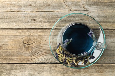 Photo of Delicious butterfly pea flower tea on wooden table, top view. Space for text