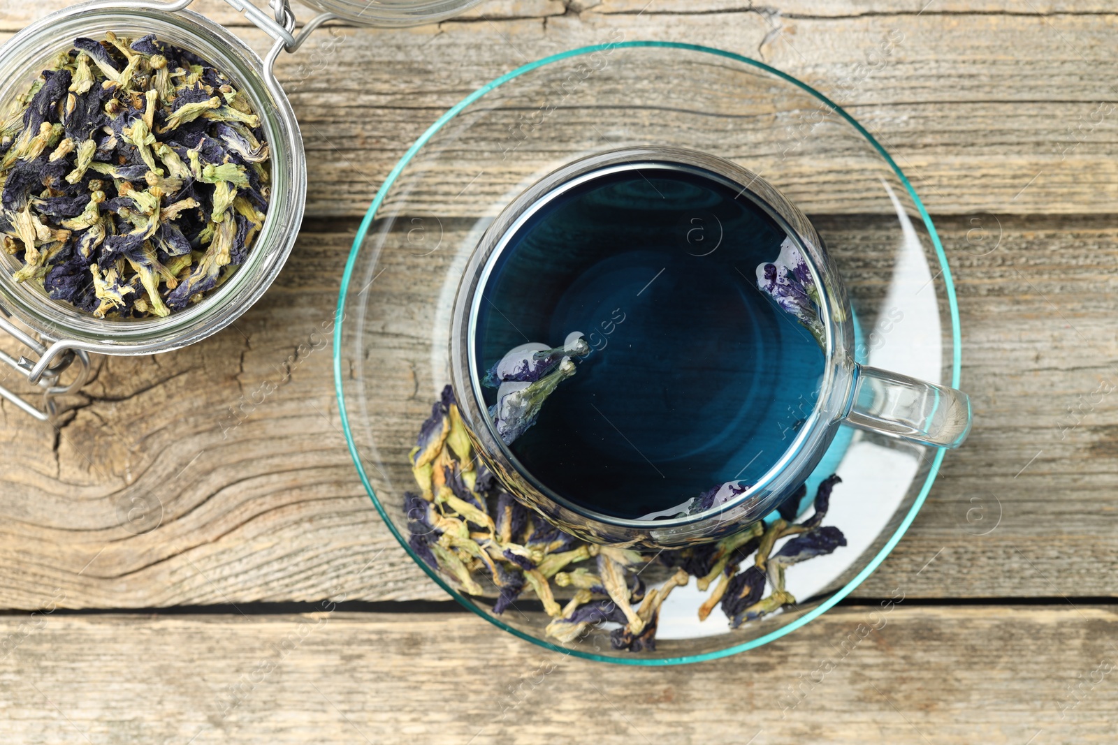 Photo of Delicious butterfly pea flower tea on wooden table, flat lay