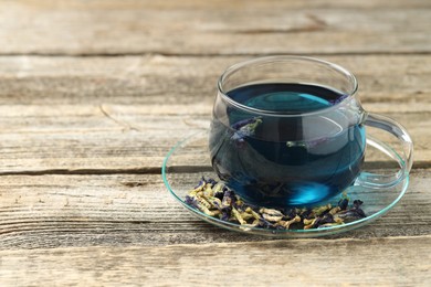 Photo of Delicious butterfly pea flower tea on wooden table, space for text