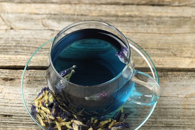 Photo of Delicious butterfly pea flower tea on wooden table, closeup