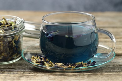 Photo of Delicious butterfly pea flower tea on wooden table, closeup