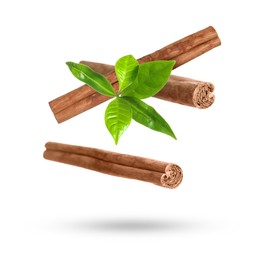 Image of Cinnamon sticks and green leaves in air on white background