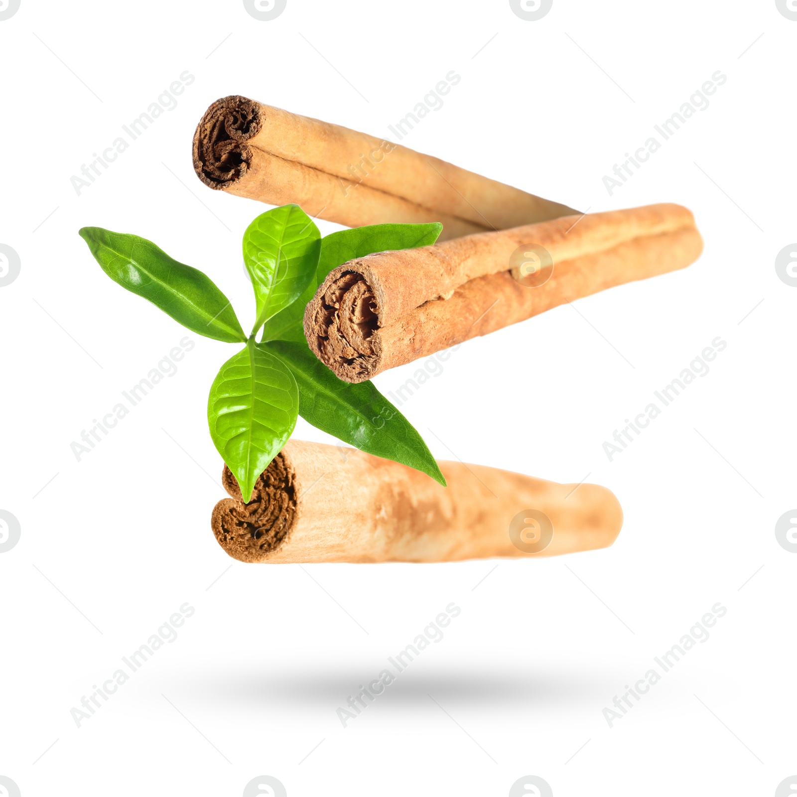 Image of Cinnamon sticks and green leaves in air on white background