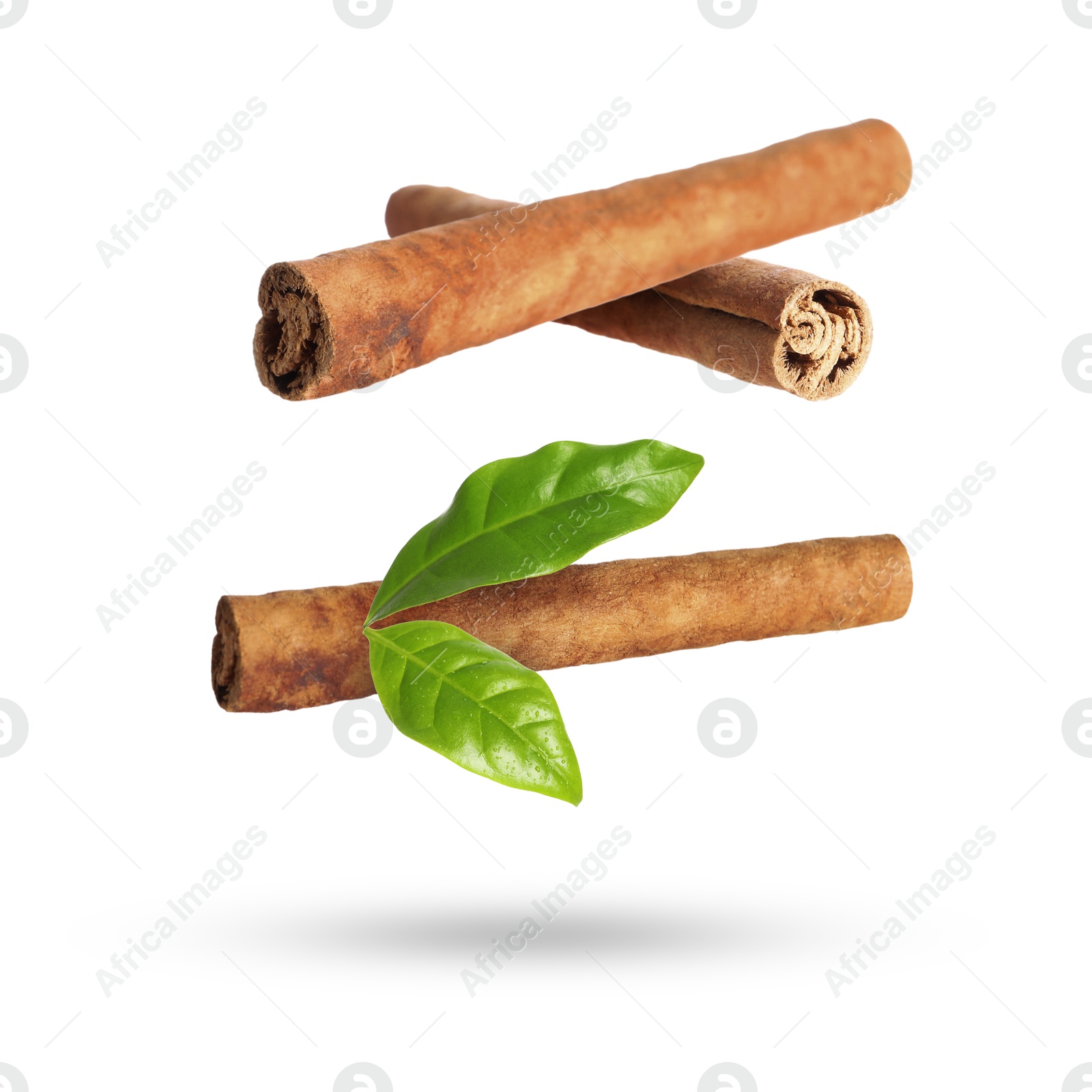 Image of Cinnamon sticks and green leaves in air on white background