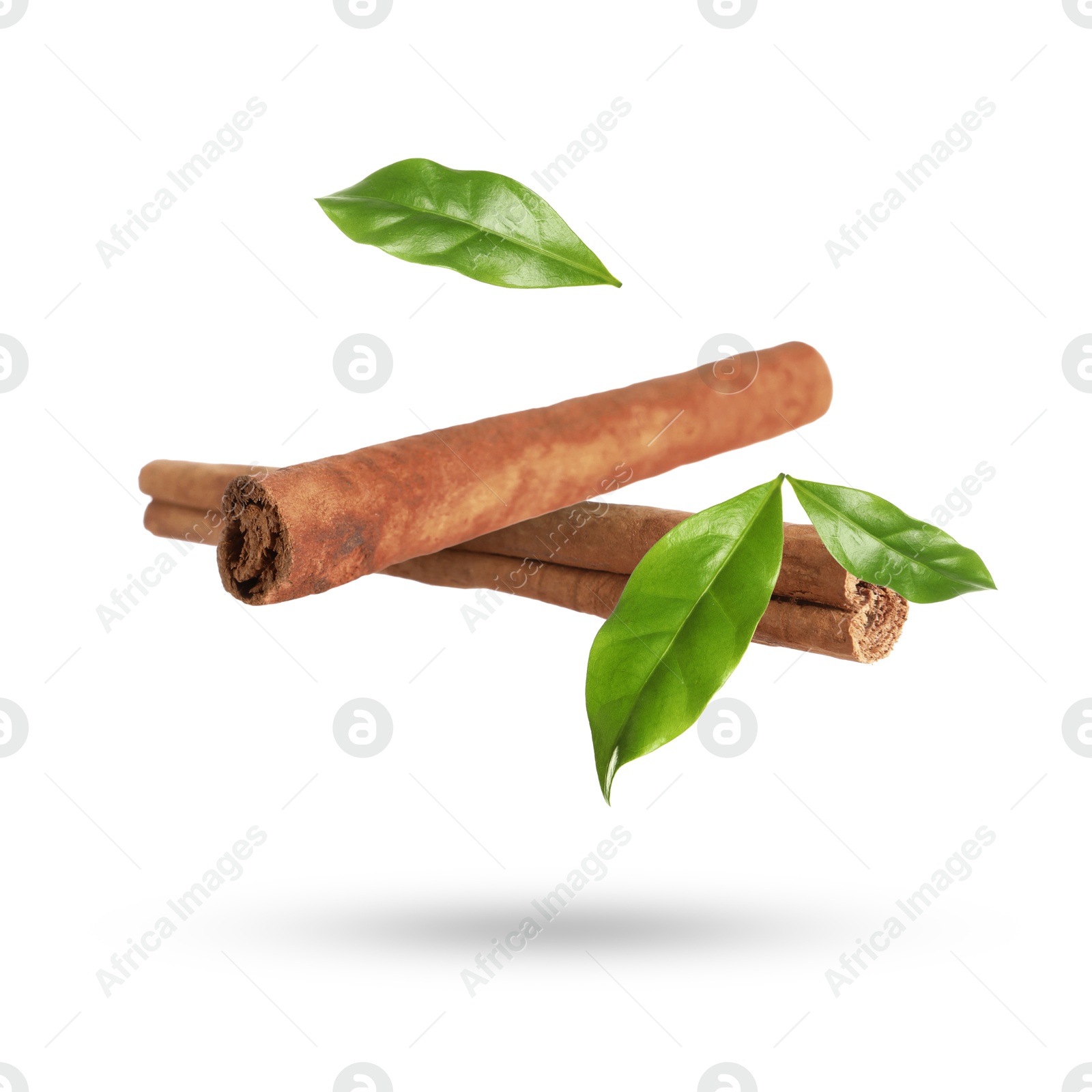 Image of Cinnamon sticks and green leaves in air on white background