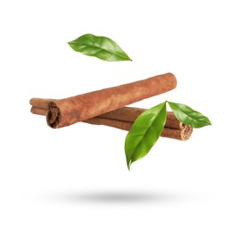 Image of Cinnamon sticks and green leaves in air on white background