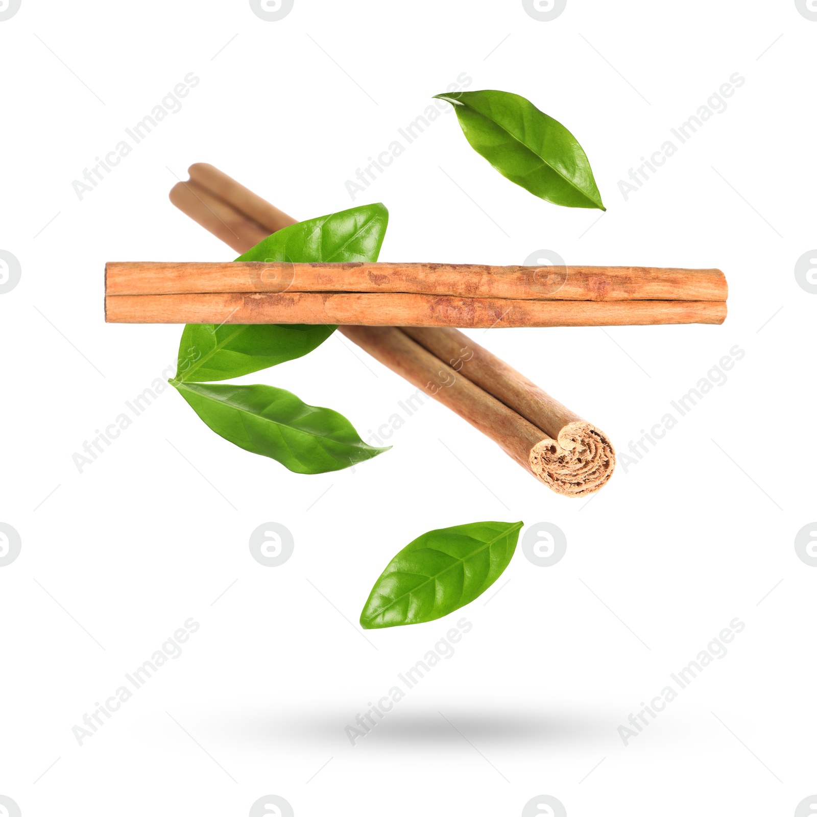 Image of Cinnamon sticks and green leaves in air on white background