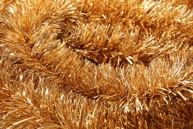 Photo of Shiny golden tinsel as background, closeup view