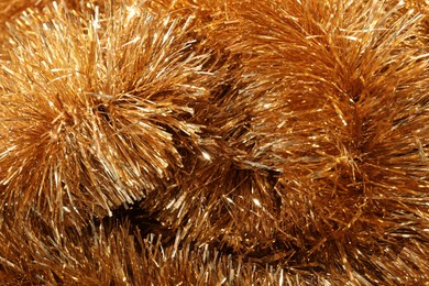 Photo of Shiny golden tinsel as background, closeup view