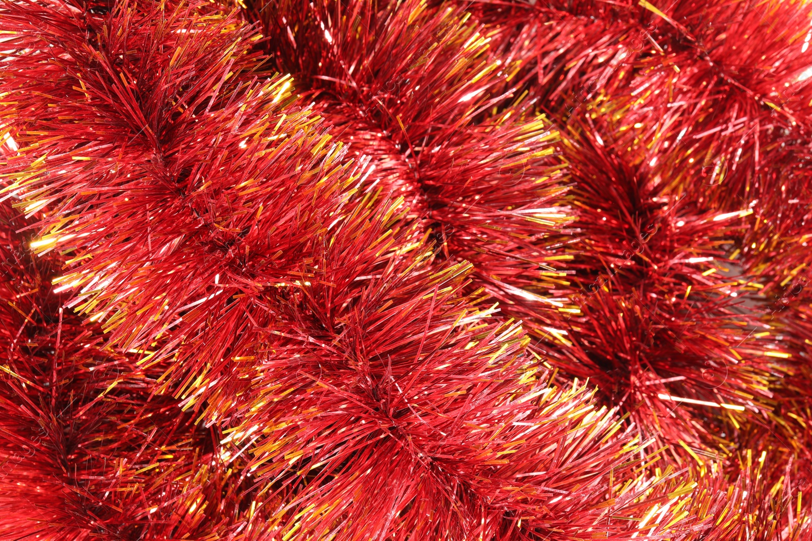 Photo of Shiny red tinsel as background, closeup view