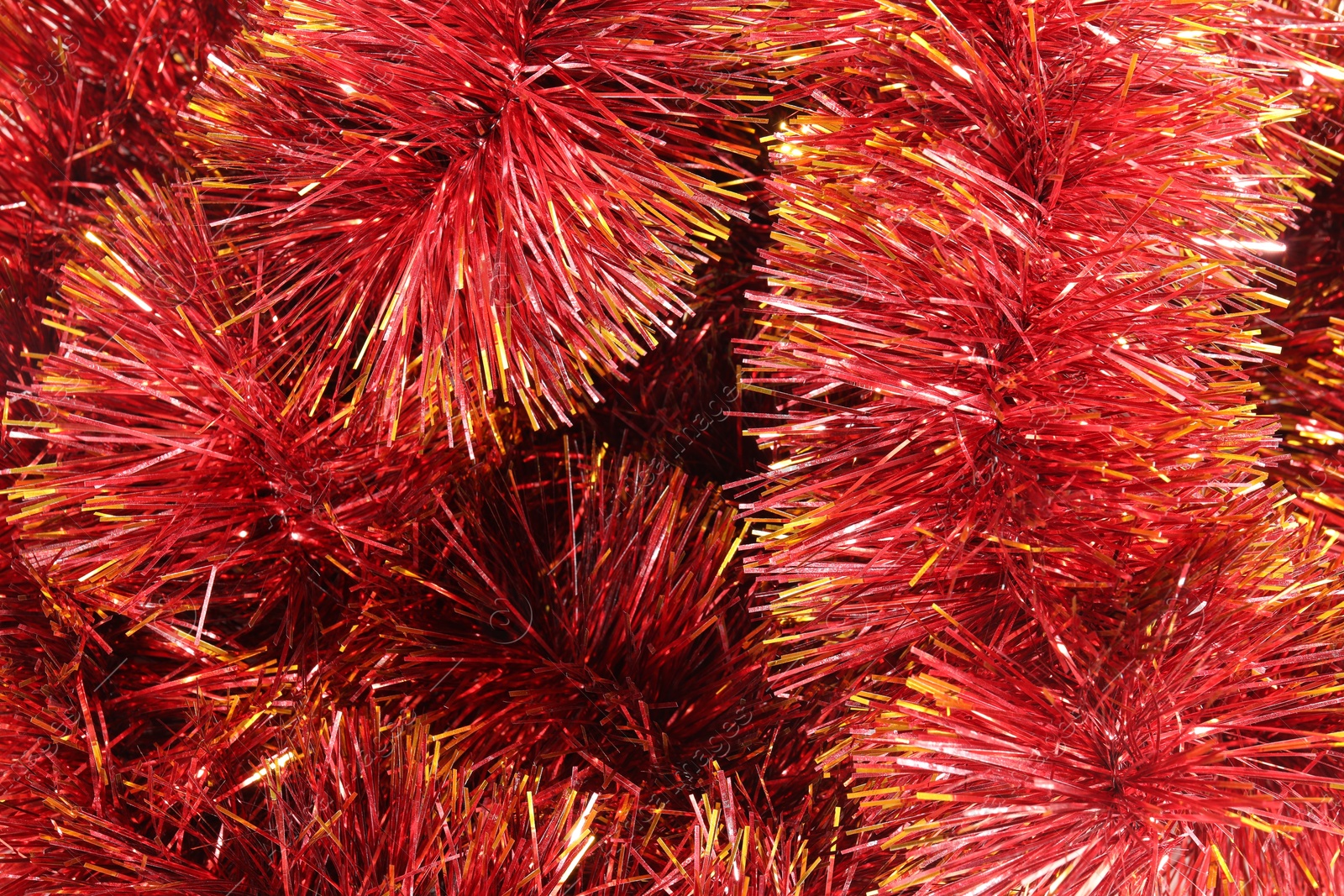 Photo of Shiny red tinsel as background, closeup view