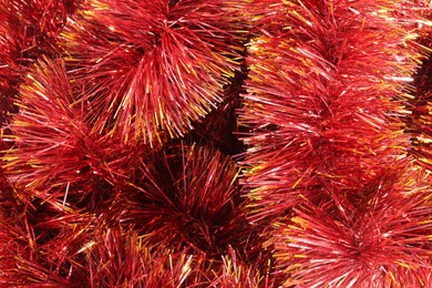 Photo of Shiny red tinsel as background, closeup view