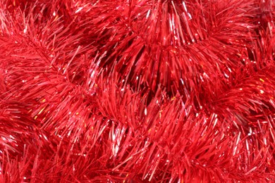 Photo of Shiny red tinsel as background, closeup view