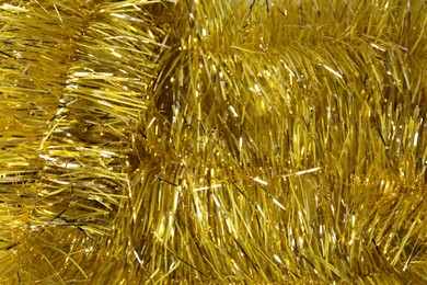 Photo of Shiny yellow tinsel as background, closeup view