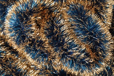 Photo of Beautiful shiny tinsel as background, closeup view