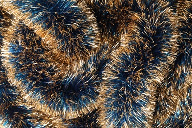 Photo of Beautiful shiny tinsel as background, closeup view