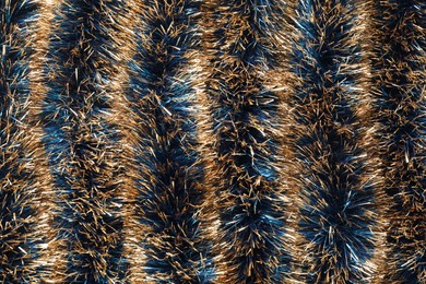 Photo of Beautiful shiny tinsel as background, closeup view