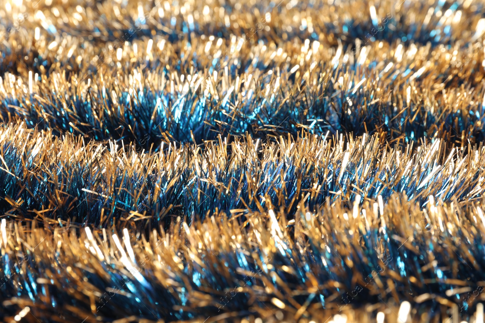 Photo of Beautiful shiny tinsel as background, closeup view