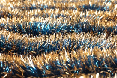 Photo of Beautiful shiny tinsel as background, closeup view