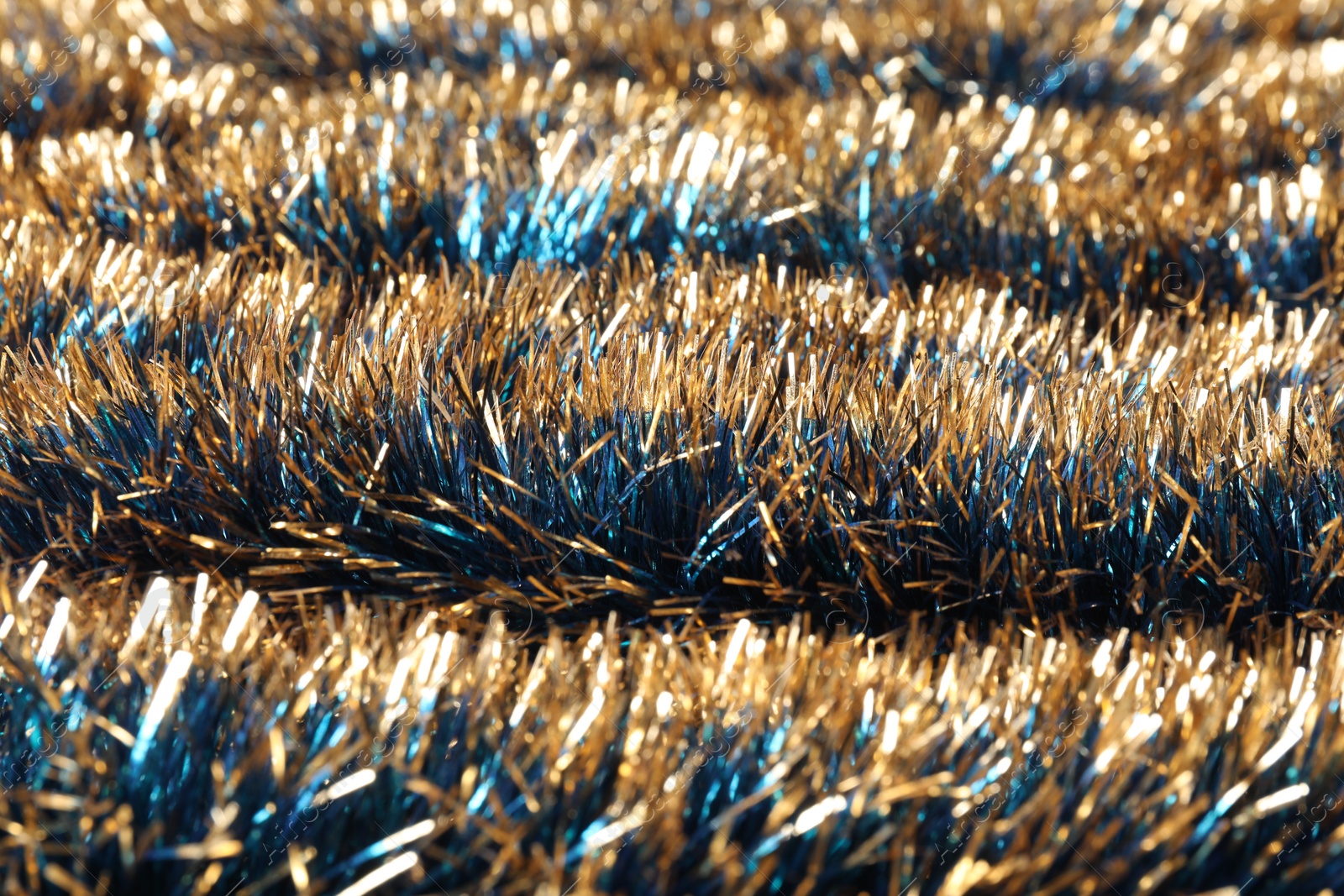 Photo of Beautiful shiny tinsel as background, closeup view