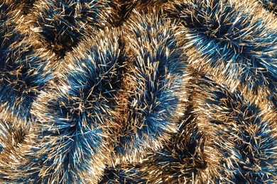 Photo of Beautiful shiny tinsel as background, closeup view