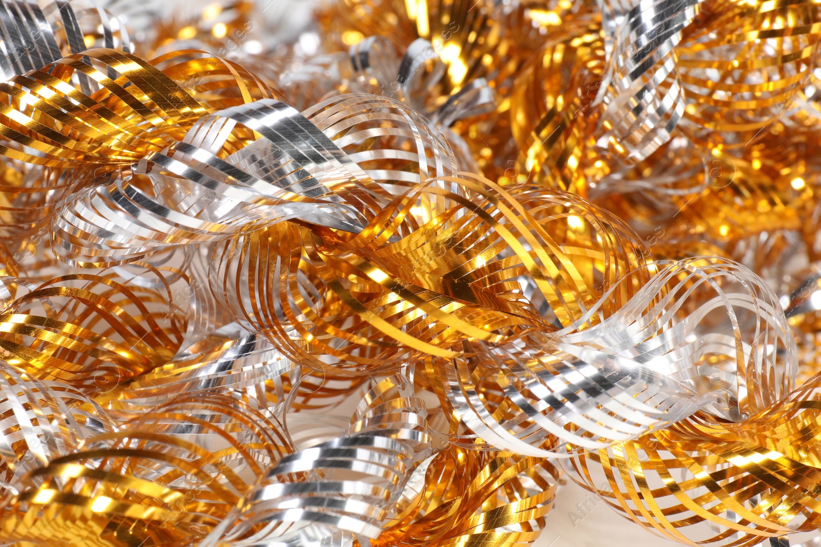 Photo of Beautiful shiny tinsel as background, closeup view