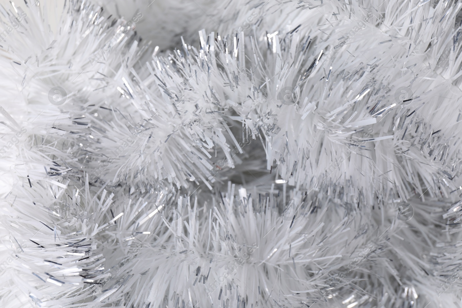 Photo of Shiny white tinsel as background, closeup view