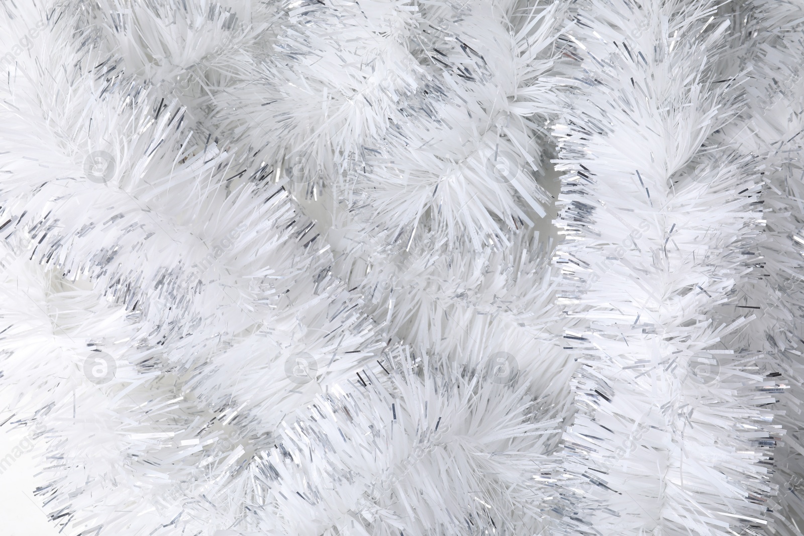 Photo of Shiny white tinsel as background, closeup view