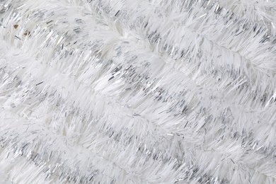 Photo of Shiny white tinsel as background, closeup view