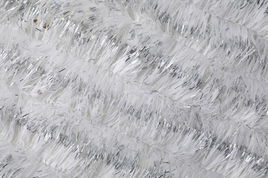 Photo of Shiny white tinsel as background, closeup view