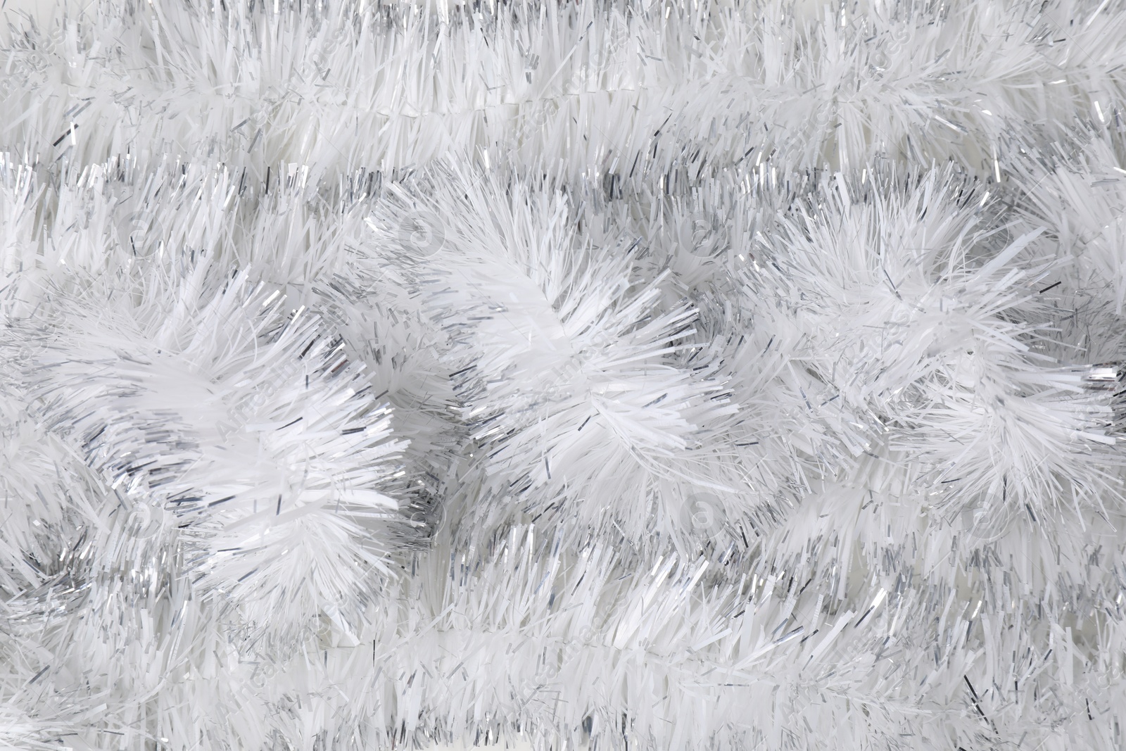 Photo of Shiny white tinsel as background, closeup view