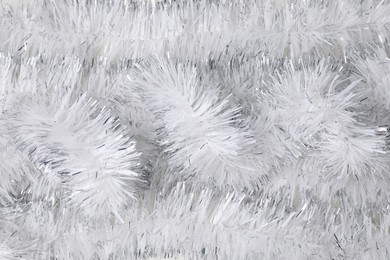 Photo of Shiny white tinsel as background, closeup view