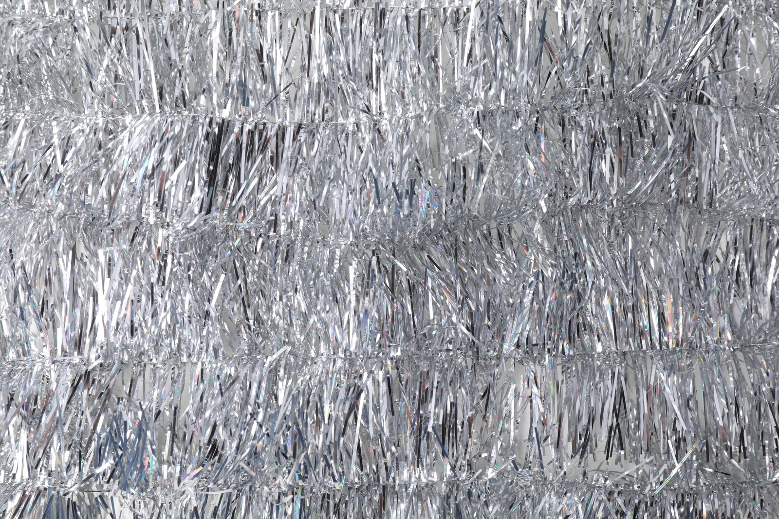 Photo of Shiny silver tinsel as background, closeup view