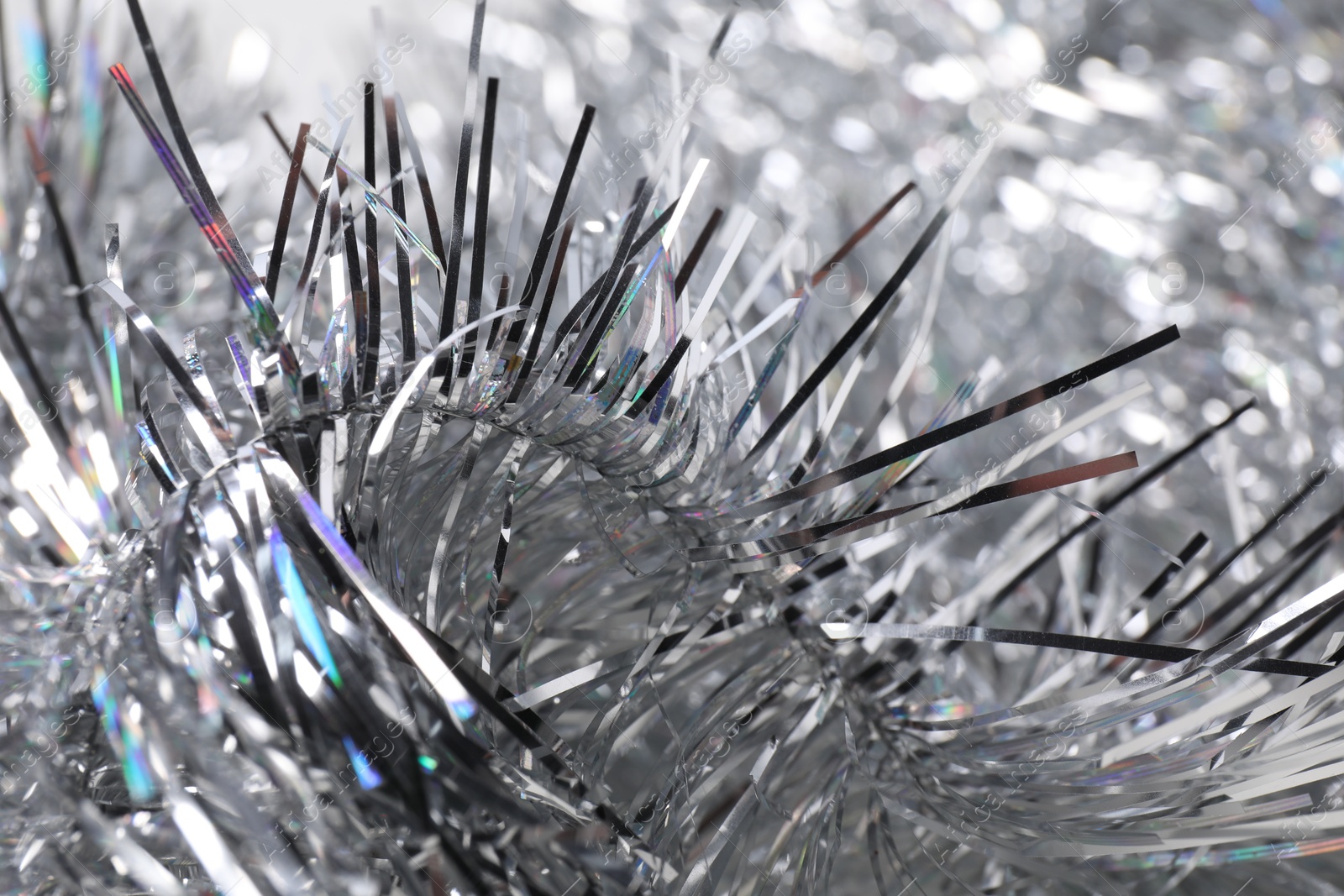 Photo of Shiny silver tinsel as background, closeup view