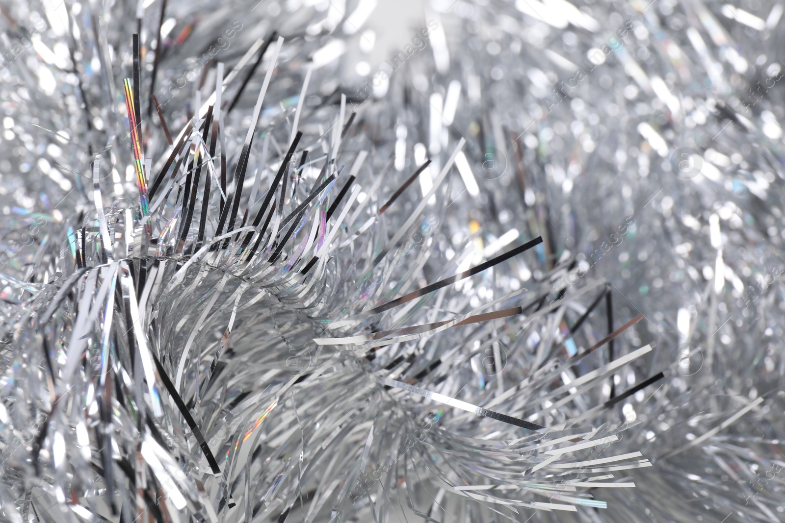 Photo of Shiny silver tinsel as background, closeup view