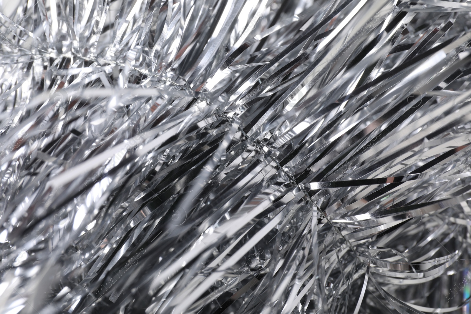 Photo of Shiny silver tinsel as background, closeup view