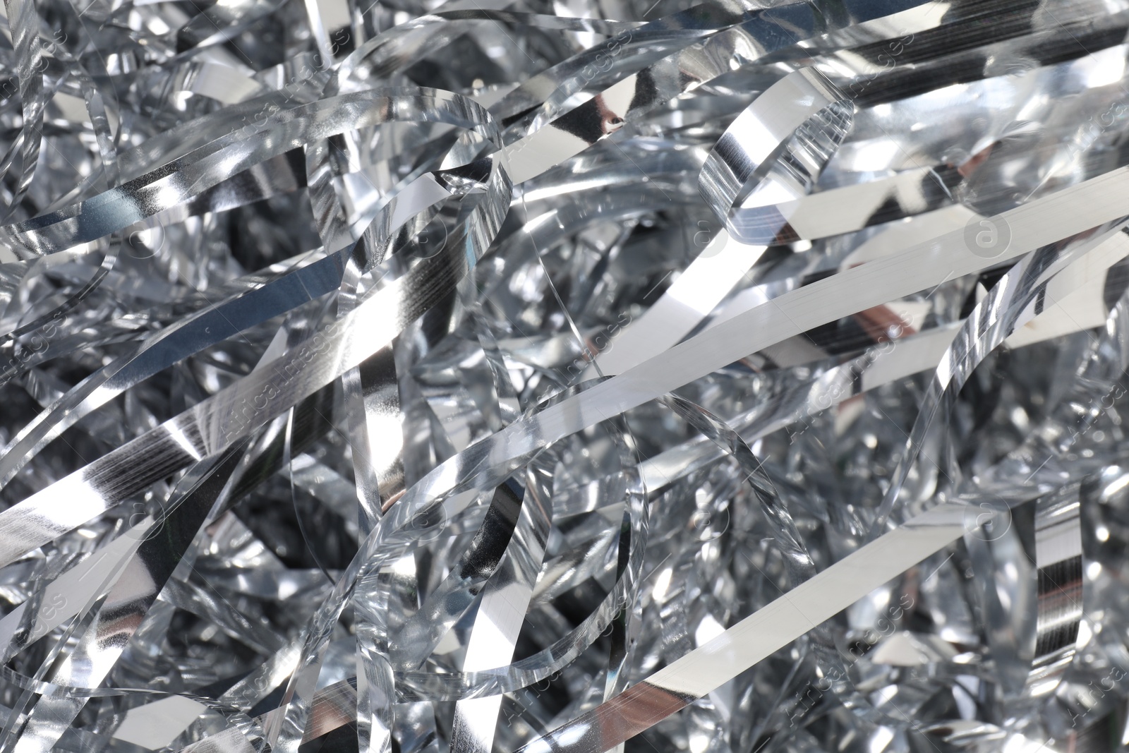 Photo of Shiny silver tinsel as background, closeup view