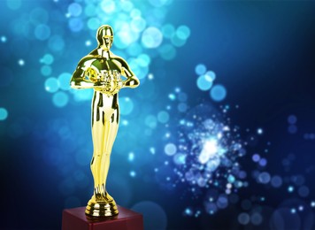 Image of Golden trophy in shape of human figure on blue gradient background with blurred lights