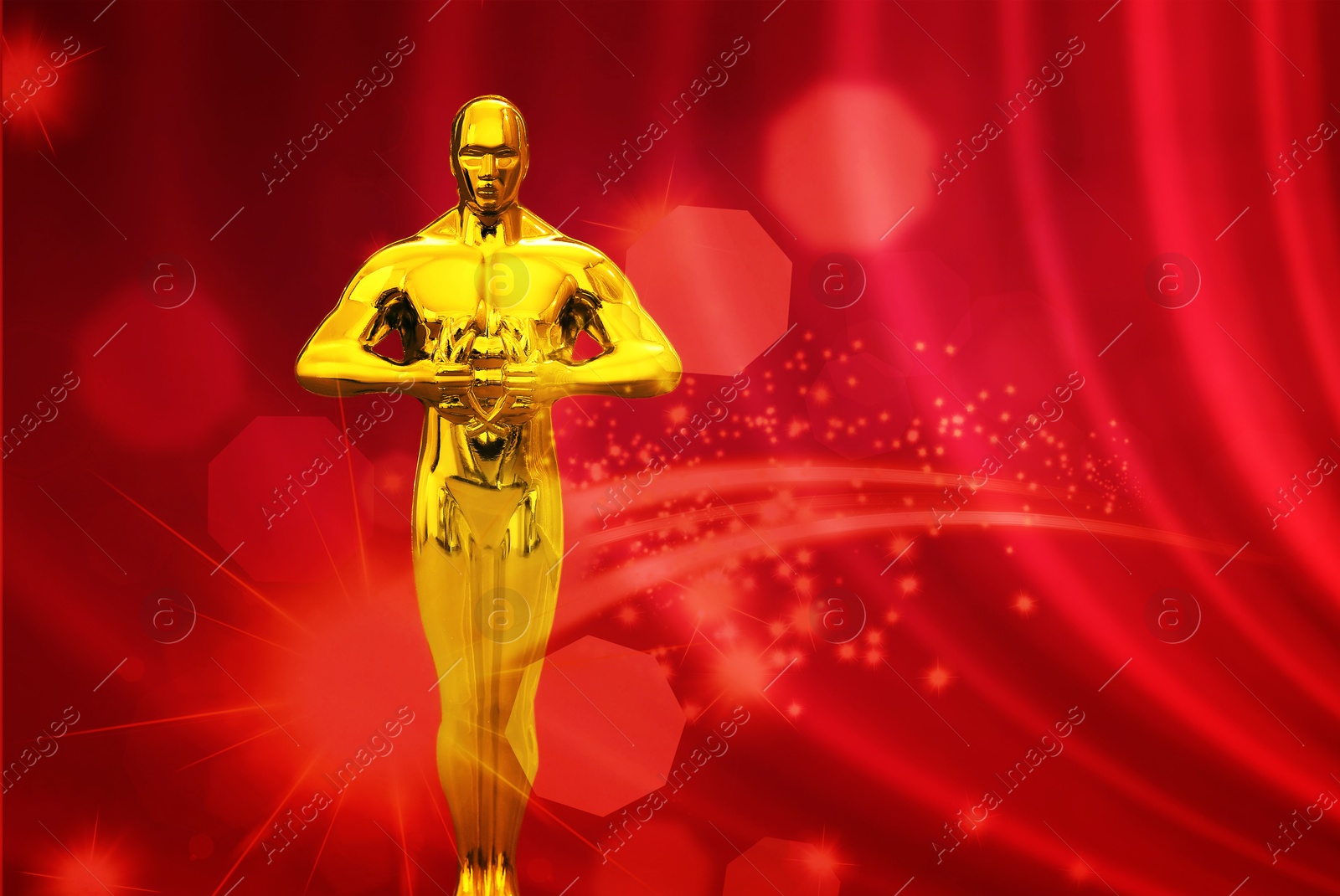 Image of Golden trophy in shape of human figure on red background. Shimmering light near statuette