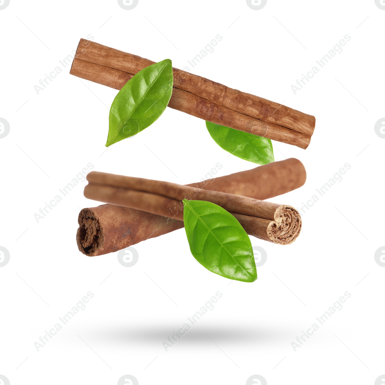 Image of Cinnamon sticks and green leaves in air on white background