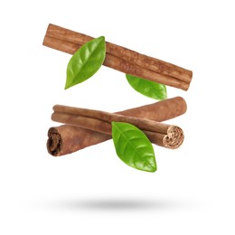 Image of Cinnamon sticks and green leaves in air on white background