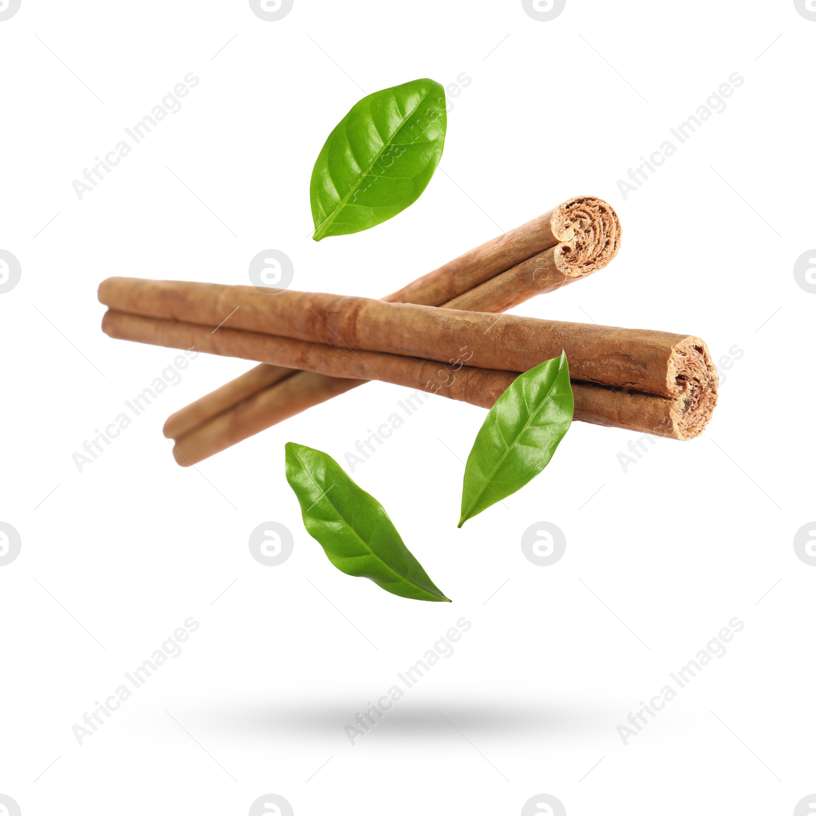 Image of Cinnamon sticks and green leaves in air on white background