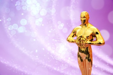 Image of Golden trophy in shape of human figure against pink shimmering background