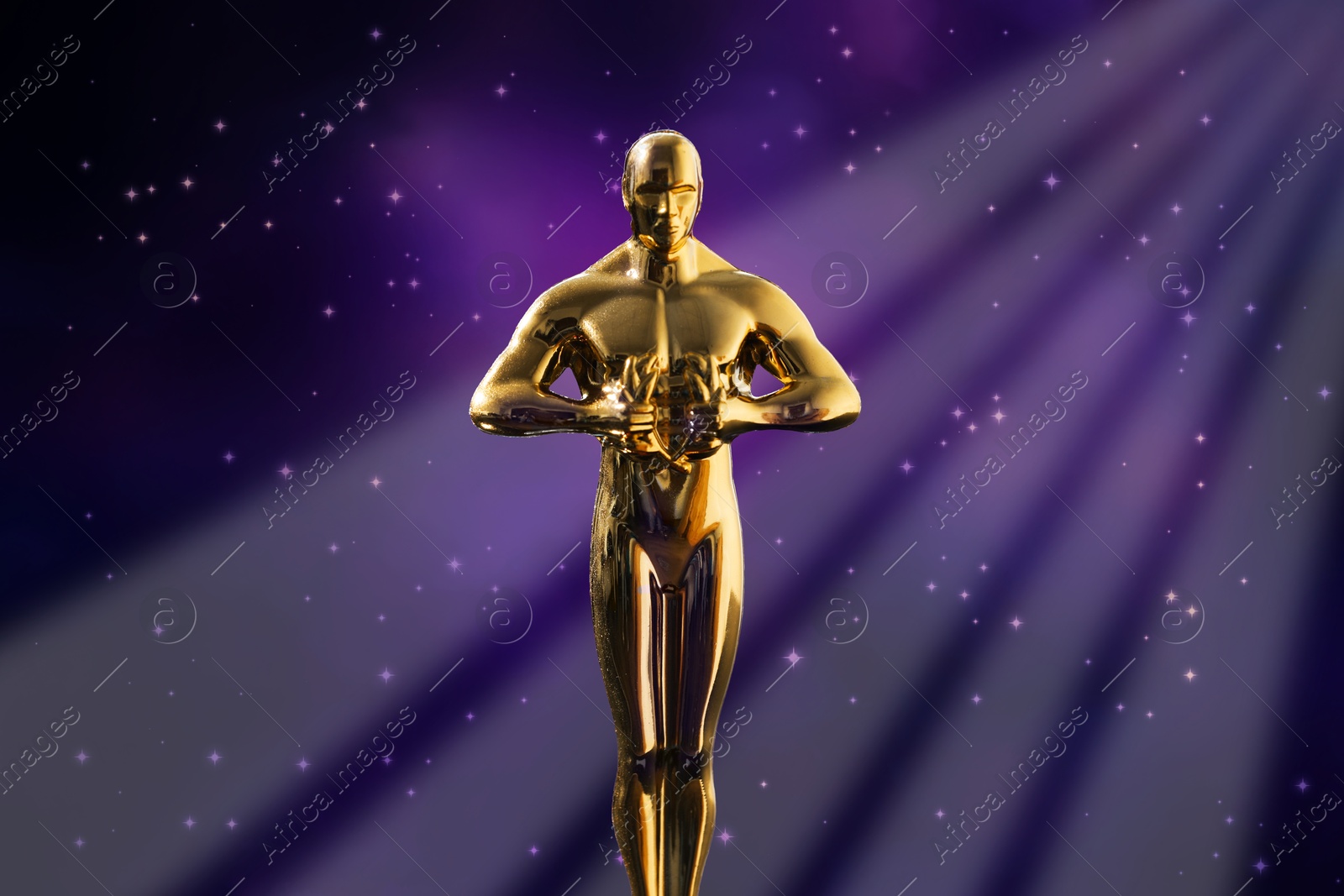 Image of Golden trophy in shape of human figure in light rays against shimmering background