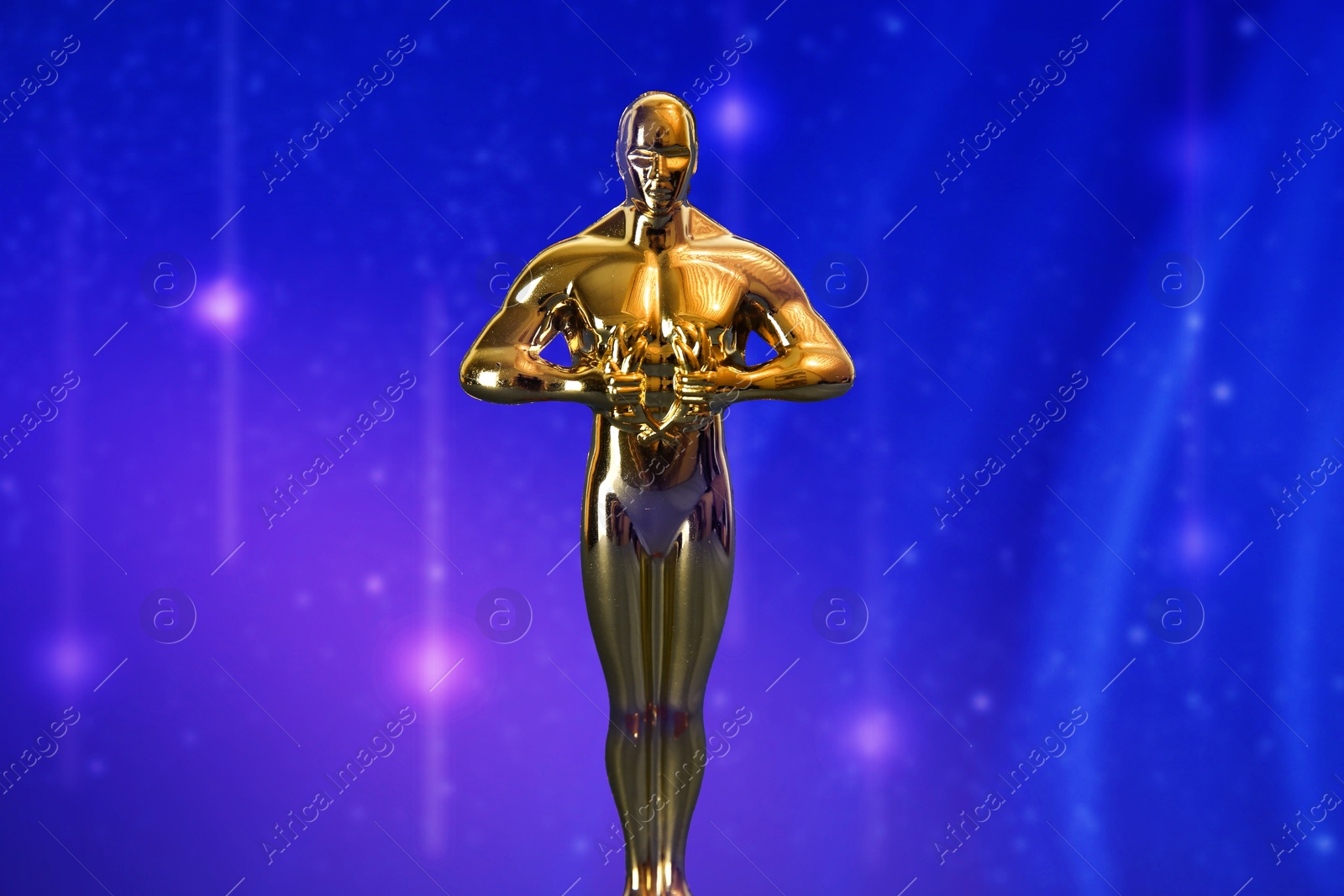 Image of Golden trophy in shape of human figure against blue violet shimmering background