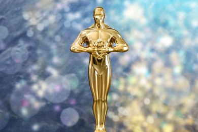 Image of Golden trophy in shape of human figure against blurred lights