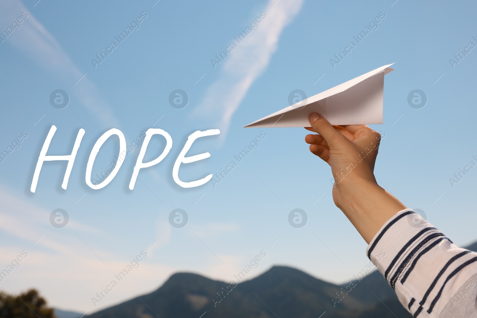 Image of Hope. Woman holding paper plane against blue sky, closeup