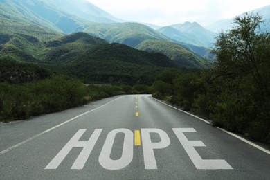 Image of Word Hope on asphalt road leading to mountains