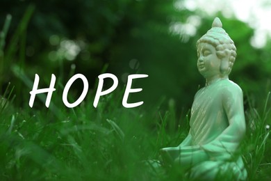 Image of Hope. Decorative Buddha statue in green grass outdoors