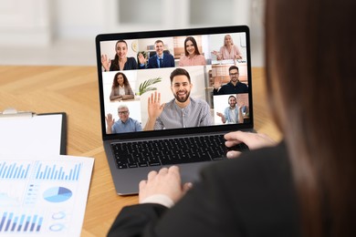 Image of Business meeting. Woman using laptop during online video chat at table, closeup